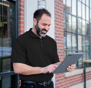 Hargray Technician holding a tablet outside of a business